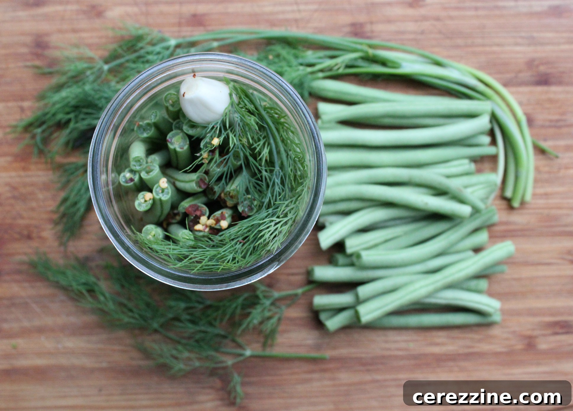 Fifty Varied Pickle Recipes From Asparagus To Zucchini 18 Glass jars filled with vibrant green dilly beans, ready for storage.