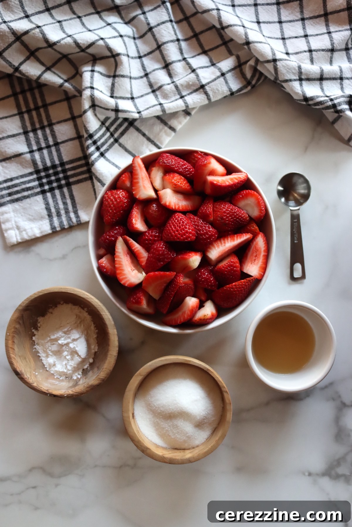 Ingredients for homemade strawberry pie filling including fresh strawberries, sugar, Clear Jel, and lemon juice