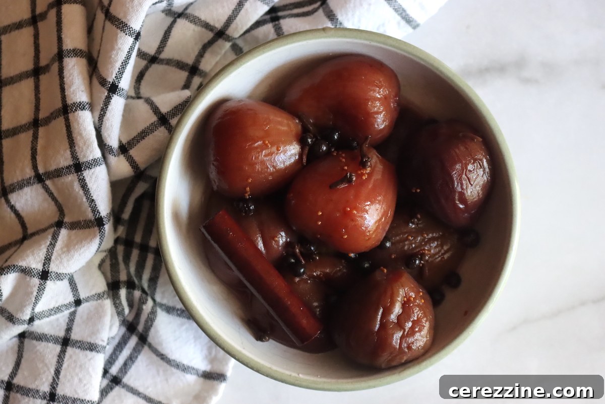 Two glass jars filled with homemade pickled figs, showcasing their rich, dark color and plump texture.