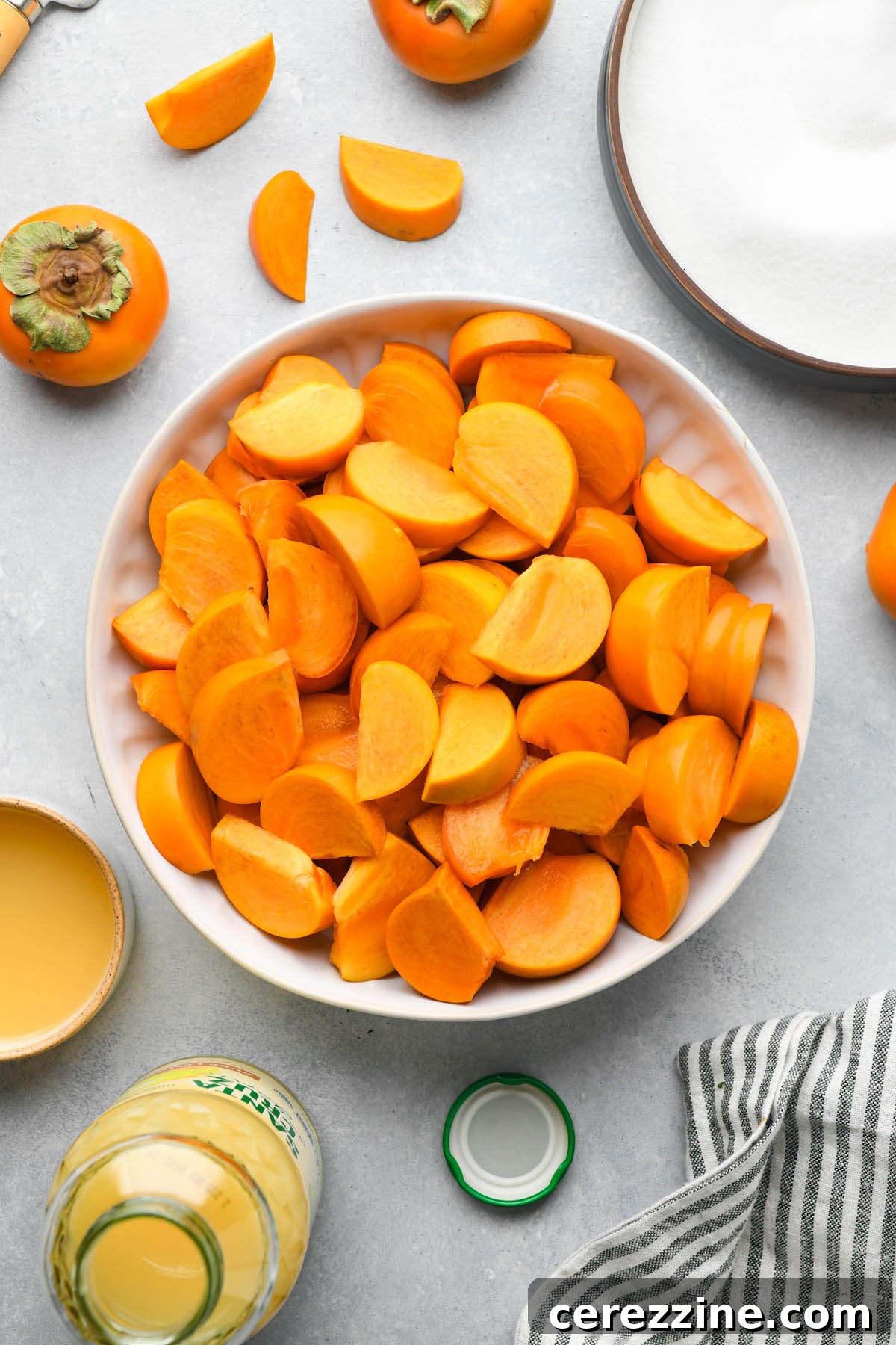 The simple ingredients laid out for making persimmon jam: persimmons, sugar, and citrus juice.