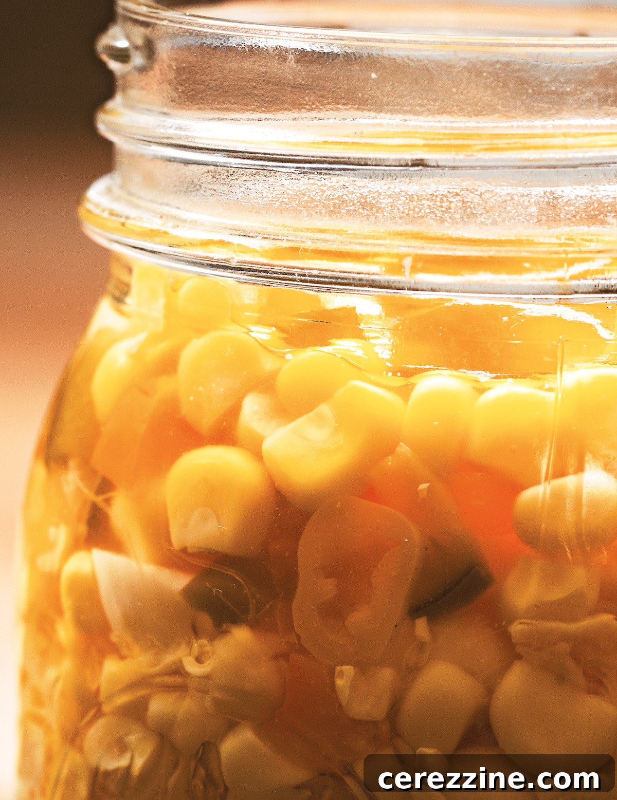 Freshly canned jars of pickled corn salad cooling on a counter