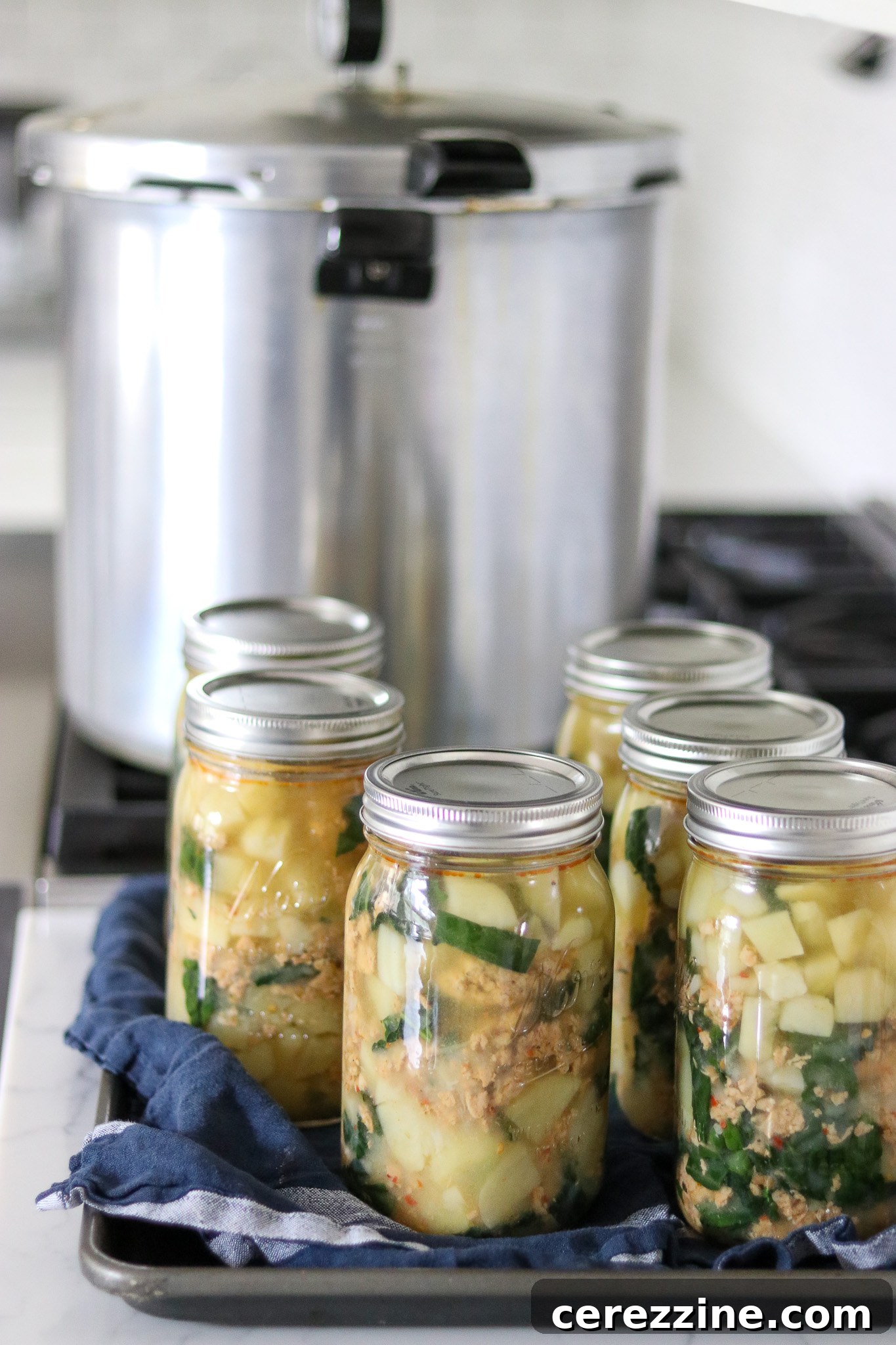 Canned Sausage Potato and Kale Soup jars on a counter
