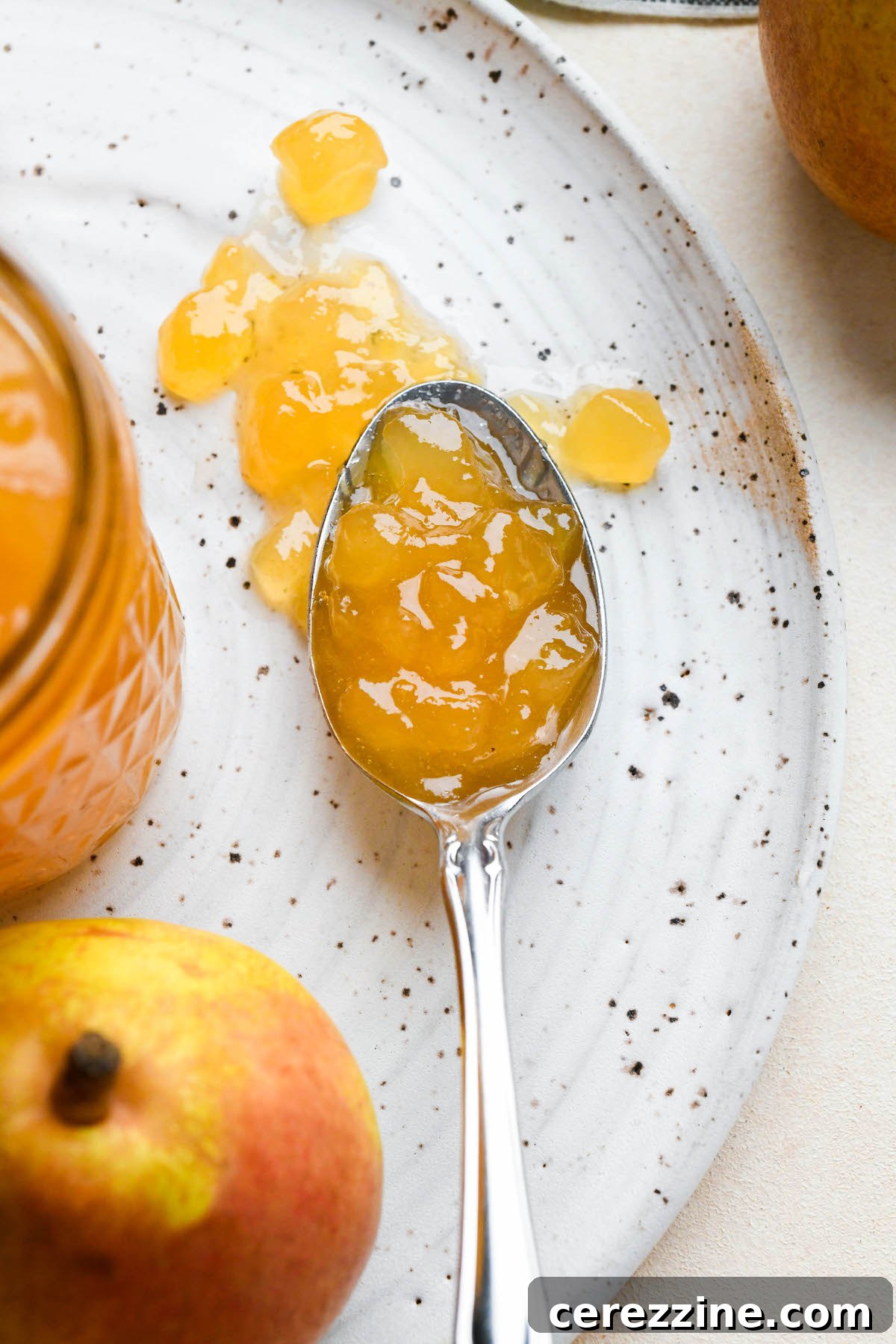 Sun Kissed Pear Jam 3 Close-up of a jar of homemade pear jam, highlighting its golden hue and chunky texture.