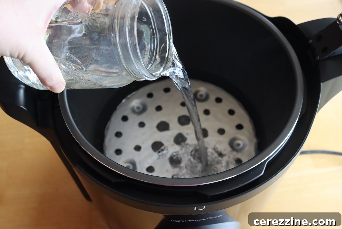 Adding water to the Presto Precise Digital Pressure Canner up to the clearly marked 3-quart fill line.