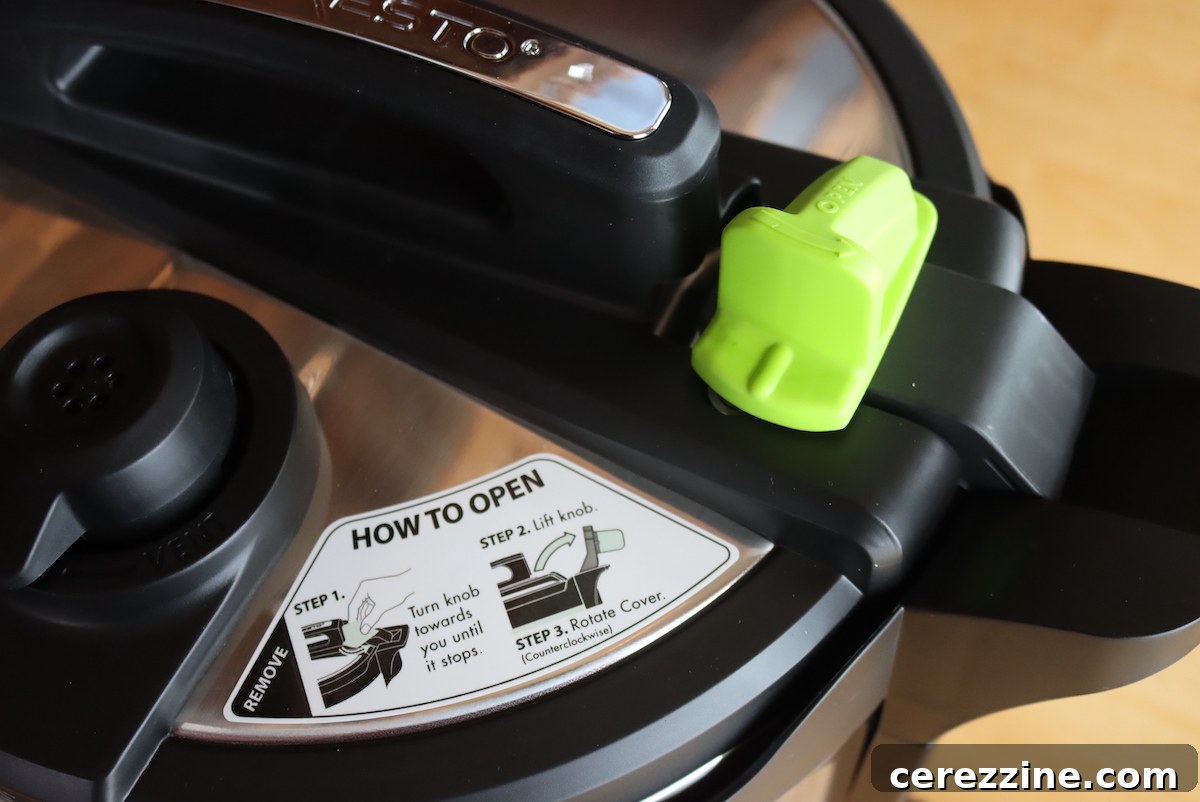 The green lock on the Presto Precise Digital Pressure Canner lid shown in the open position, indicating it needs to be turned to fully secure the lid.