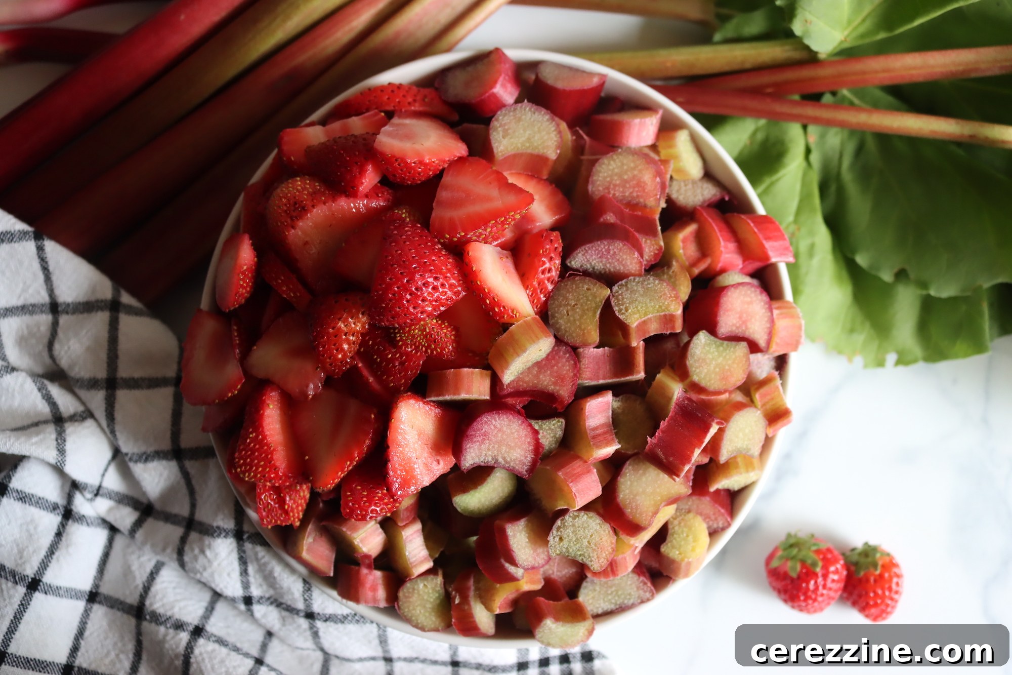 Fresh ingredients for Strawberry Rhubarb Jam: diced rhubarb, sliced strawberries, sugar, and lemon.