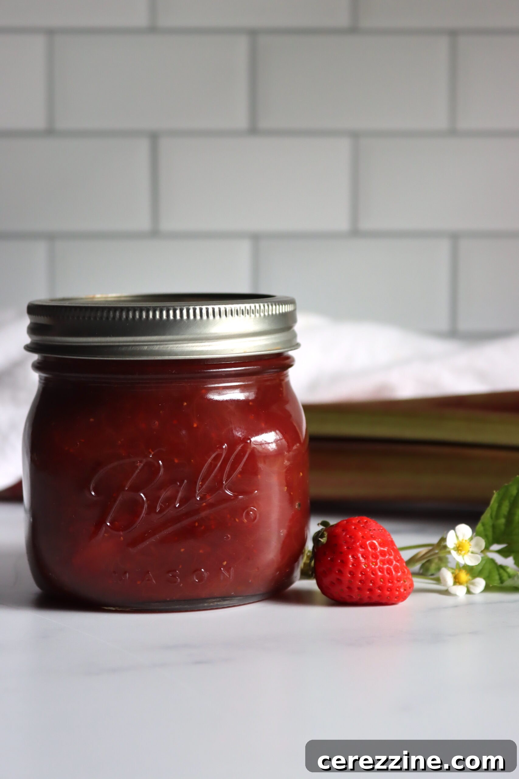 Finished Strawberry Rhubarb Jam in a jar, ready for canning or refrigeration.