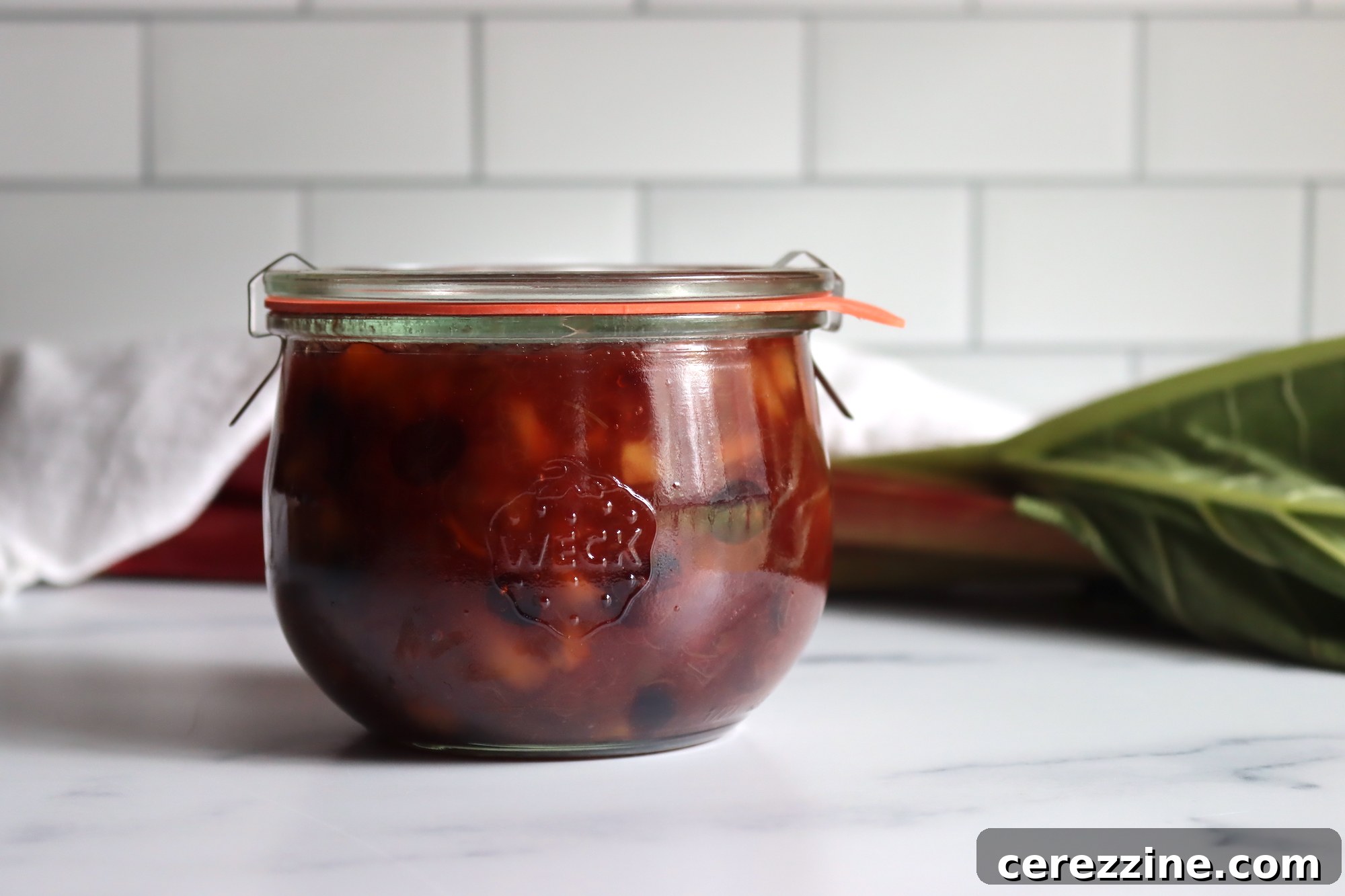 Zesty Rhubarb Chutney 5 Canned jars of rhubarb chutney cooling on a kitchen counter
