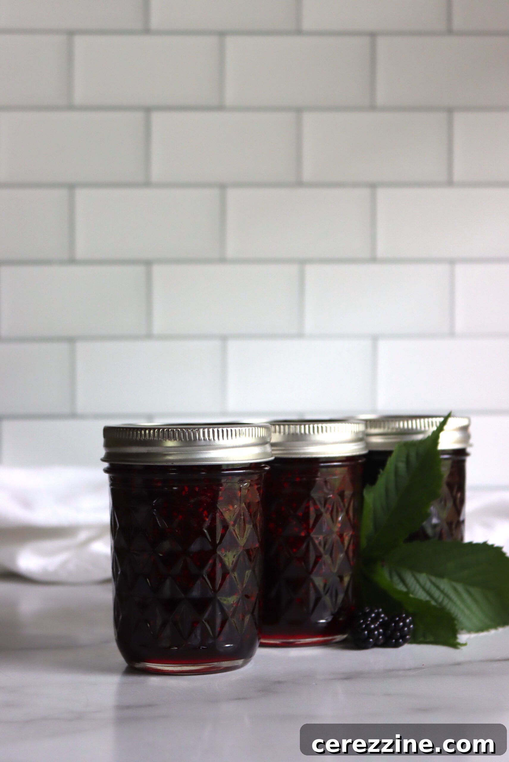 Freshly made blackberry jam in glass jars, ready for storage.