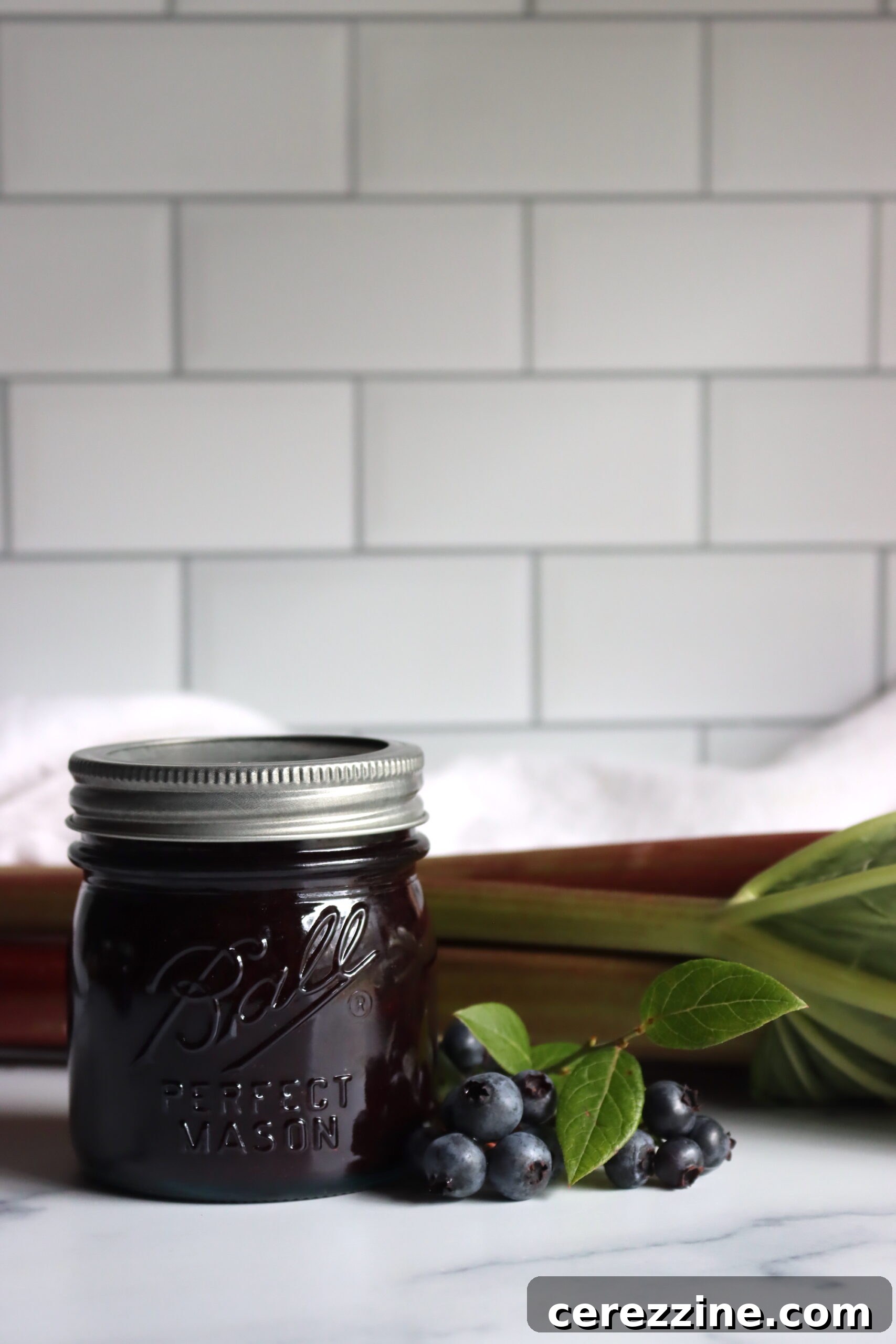 Close-up of freshly made blueberry rhubarb jam in a jar, ready for canning
