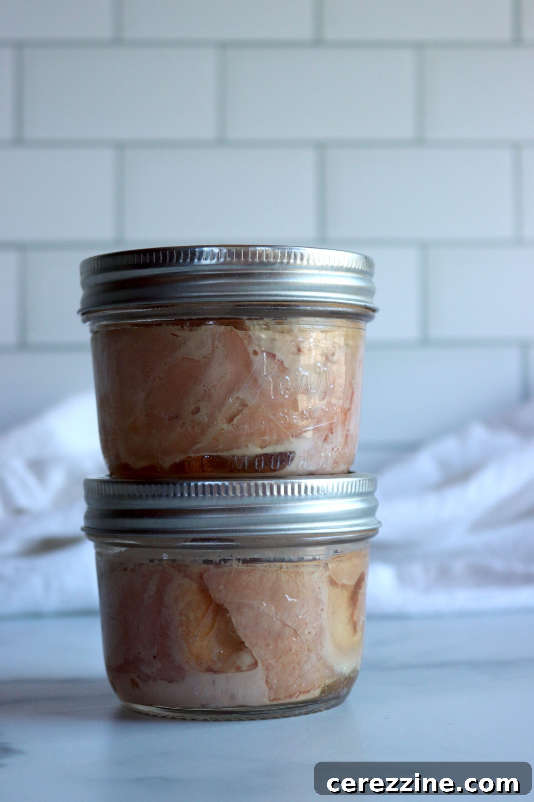 Sealed jars of home-canned tuna cooling on a counter