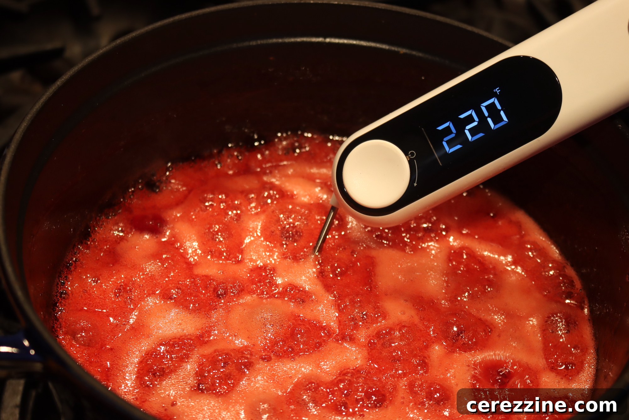Cooking Christmas Jam in a large pot, showing the vibrant fruit mixture.