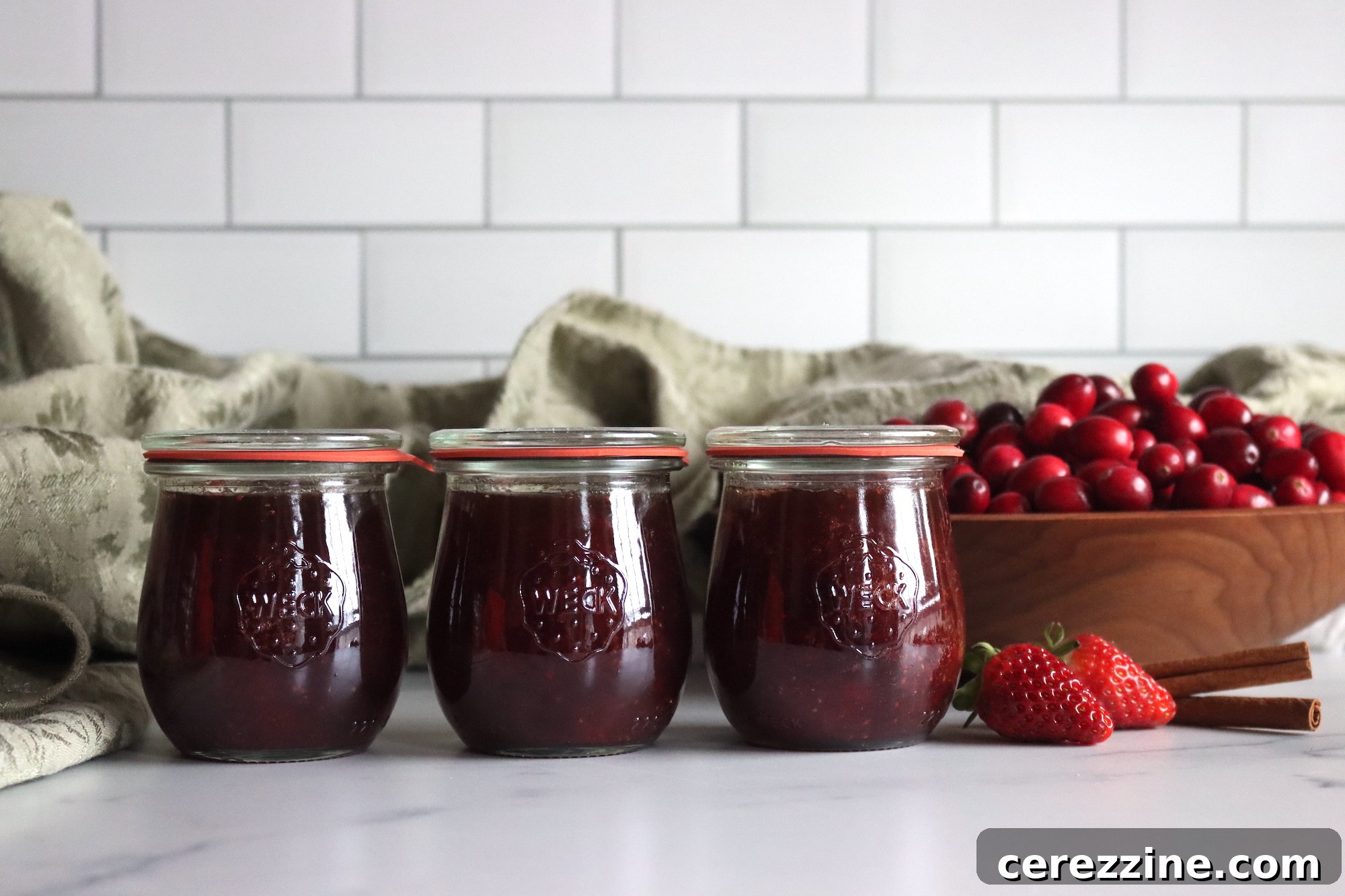 Sealed jars of Christmas Jam cooling on a rack after water bath canning.