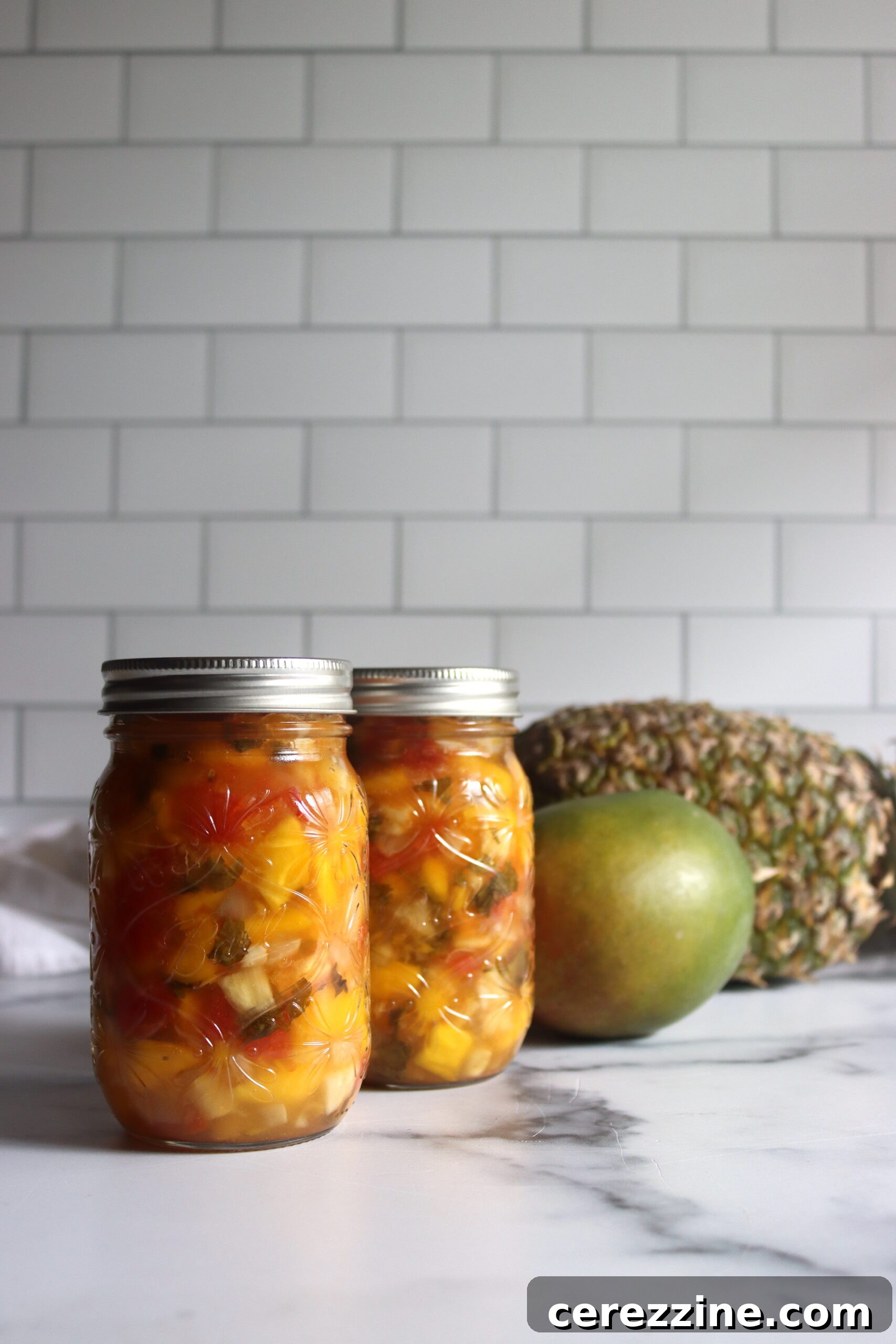 Freshly chopped ingredients for Pineapple Mango Salsa, including pineapple, mango, tomatoes, bell peppers, and habaneros.