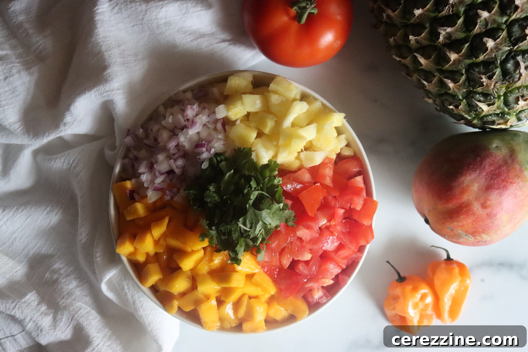 Close-up of Pineapple Mango Salsa simmering in a large pot, with vibrant colors visible.
