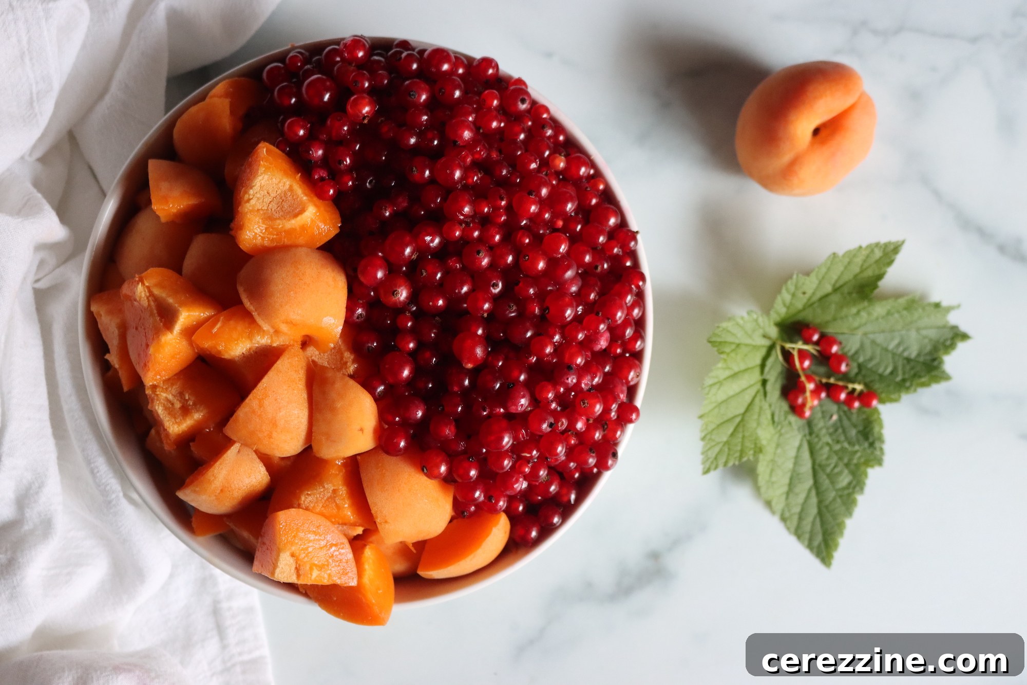 Fresh apricots and red currants on a wooden surface