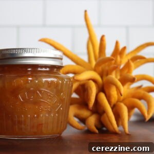 A jar of Buddha's Hand Marmalade next to a Buddha's Hand citron.