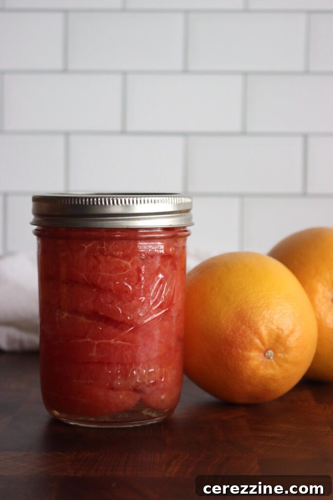 A close-up of a vibrant pink grapefruit section