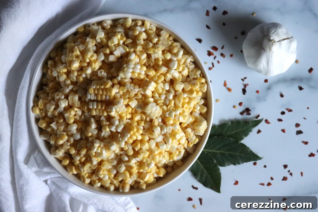 Ingredients laid out for making pickled corn: corn, jalapeño, garlic, red pepper flakes, bay leaf, vinegar, water, sugar, salt. SEO: Pickled Corn Ingredients, Canning Supplies.