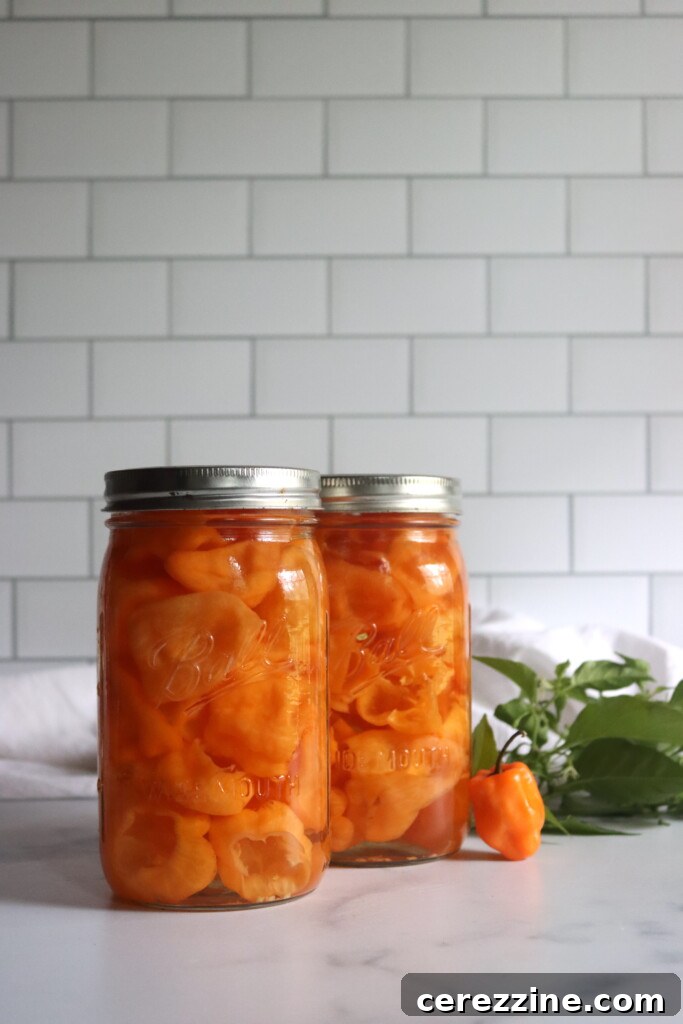 Close-up of fresh habanero peppers and a sliced garlic clove, ready to be pickled.