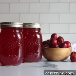 Crabapple Juice in jars on a counter next to red crabapples.