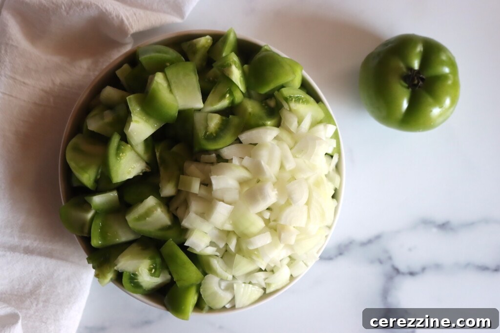 A vibrant spread of fresh ingredients laid out for making Green Tomato Chow Chow, including piles of green tomatoes, onions, and various spices.