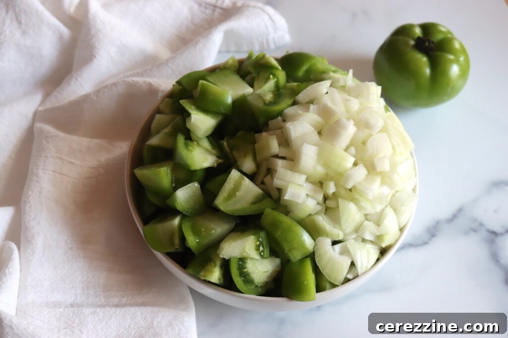 Chopped green tomatoes and onions, glistening with pickling salt, prepared for their overnight soak.