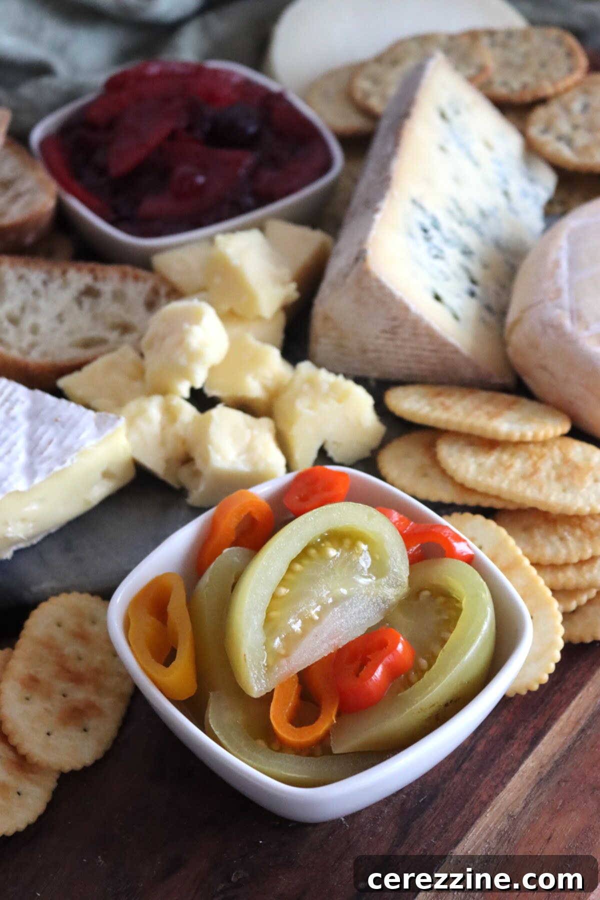 Spicy pickled green tomatoes on a cheese board.