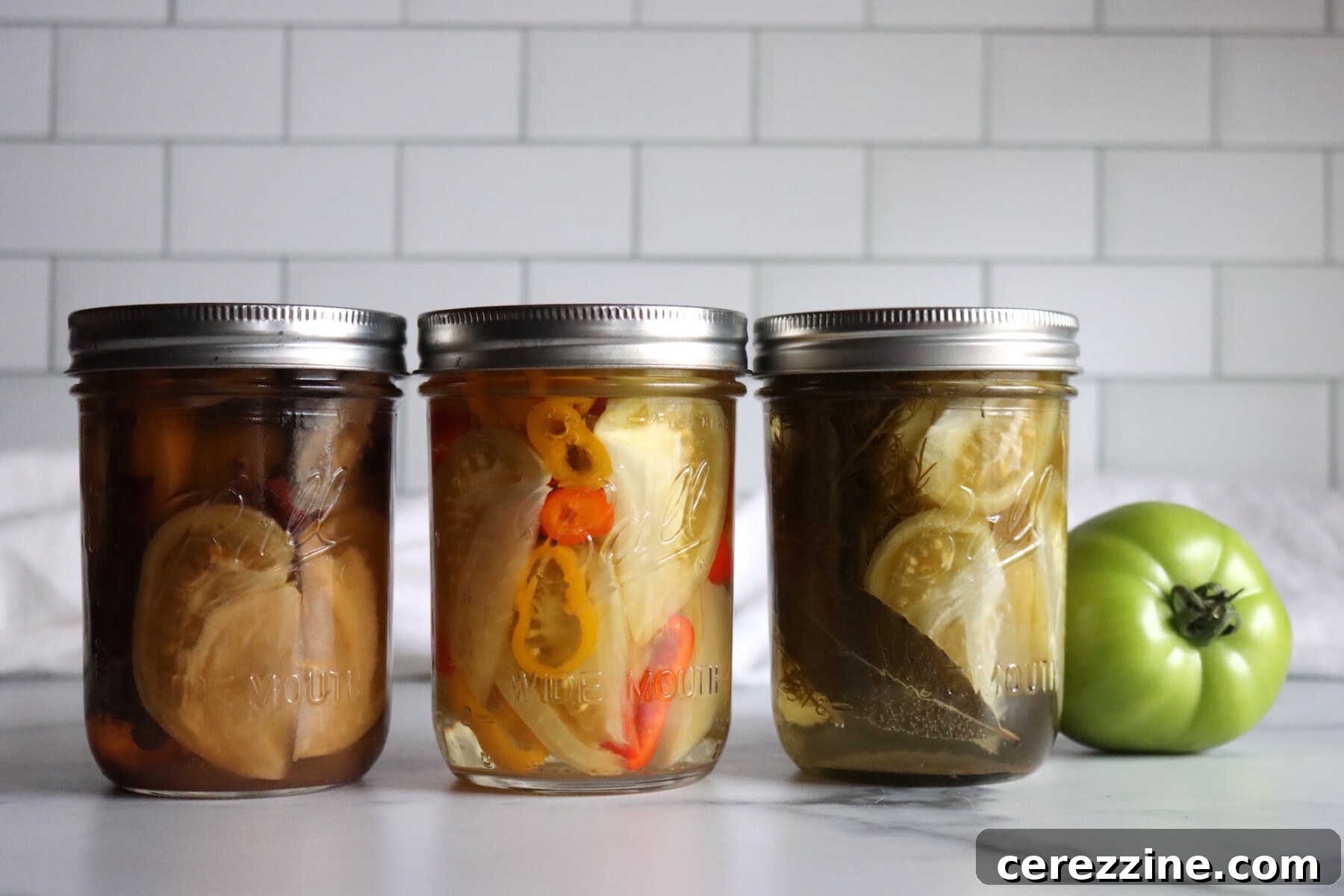 Three different pickled green tomato recipes, from left to right: Sweet, Spicy and Dill.