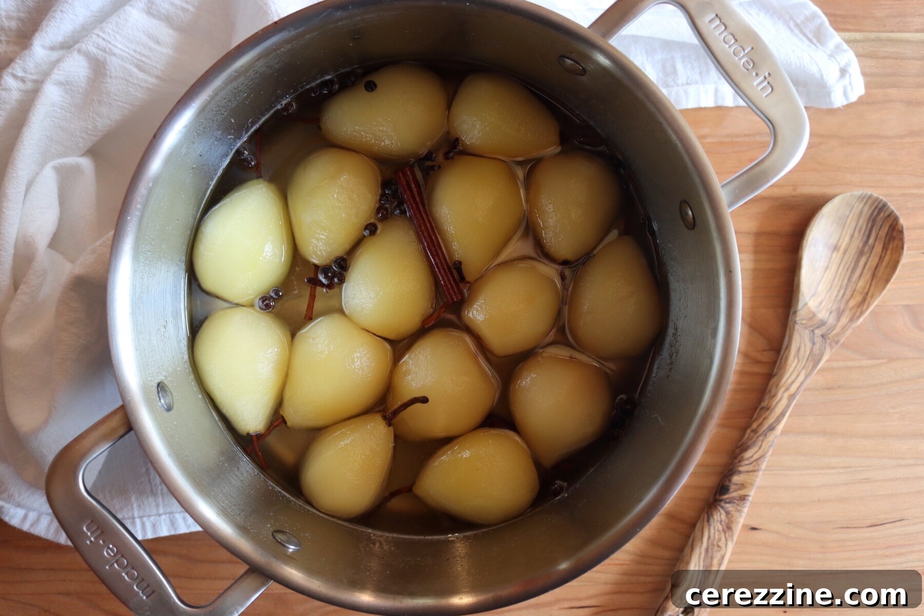 Orchard's Tangy Treasure 8 Pickled pears in a pot, infusing in syrup with sugar, vinegar and spices.
