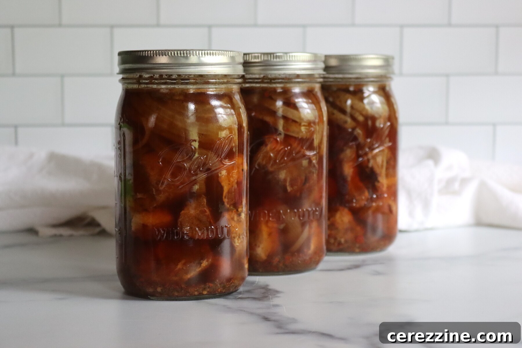 Three Jars of Ball Canning's recipe for roast pork in spicy broth.