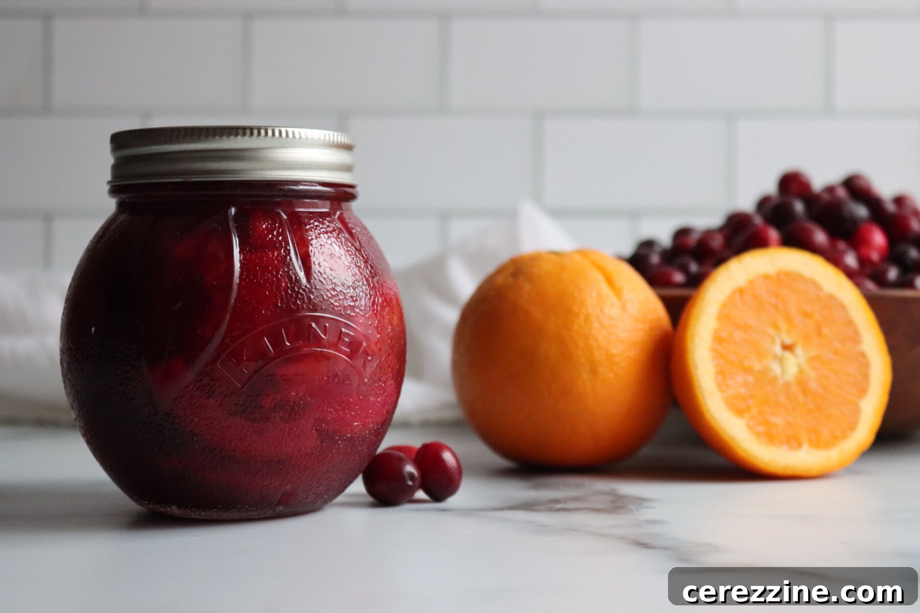 Several jars of Cranberry Orange Marmalade cooling after canning