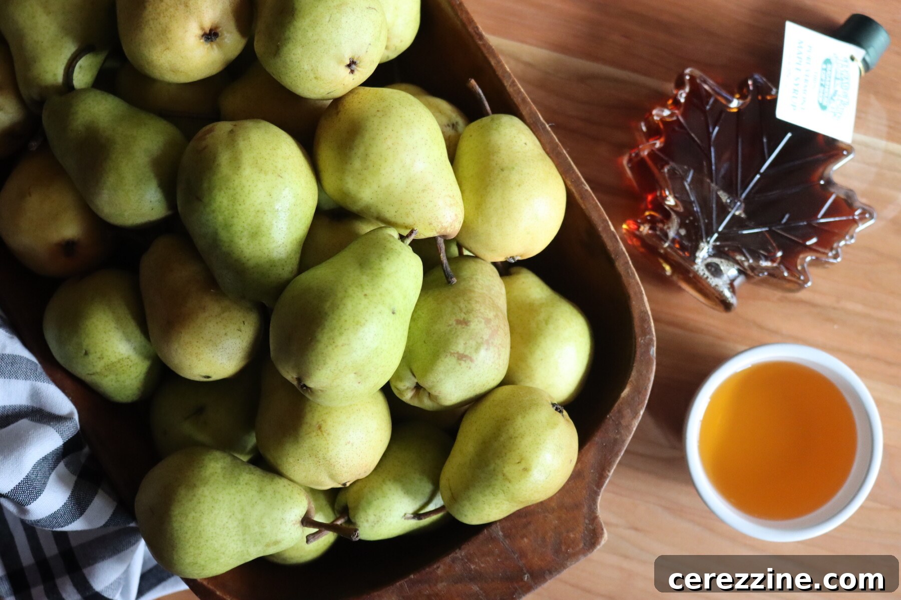 Close-up of Maple Bourbon Pear Butter ingredients: peeled and chopped pears, maple syrup, and bourbon.