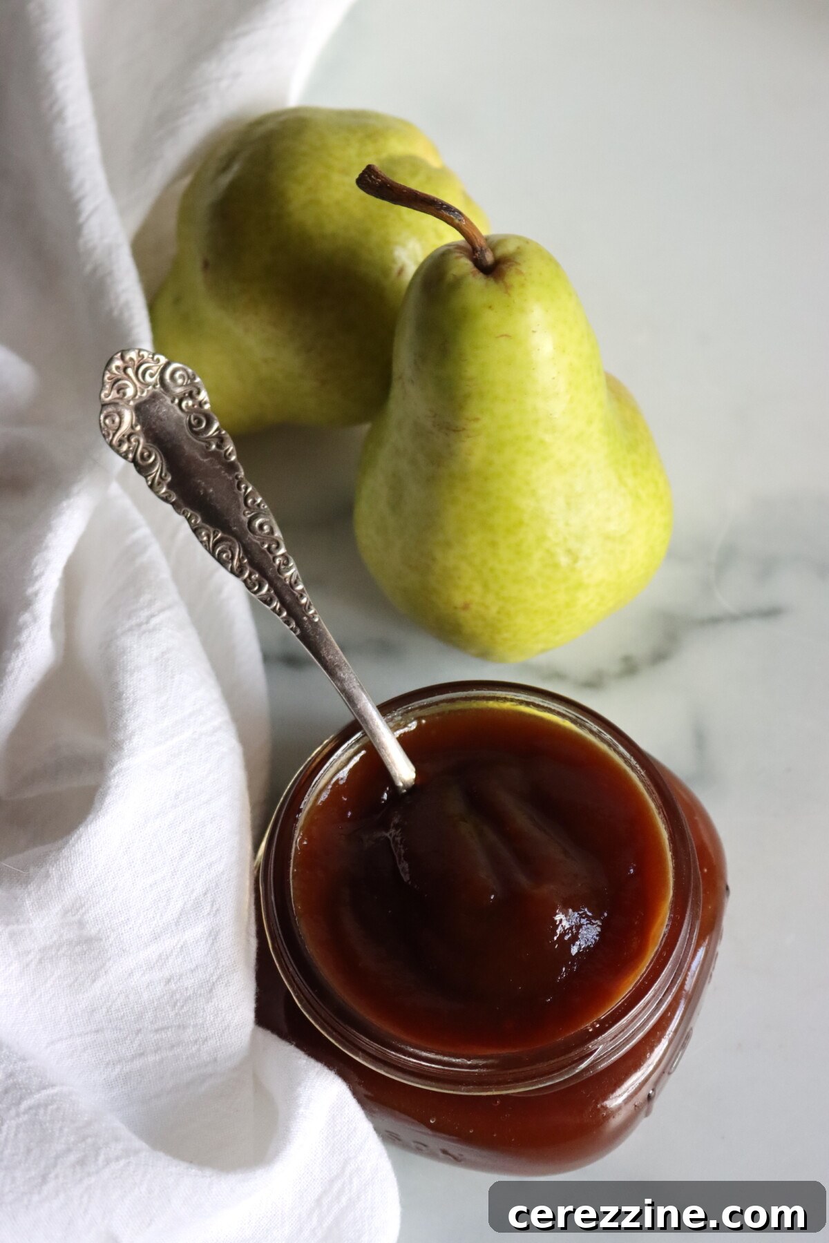 Close-up of Maple Bourbon Pear Butter being ladled into canning jars.