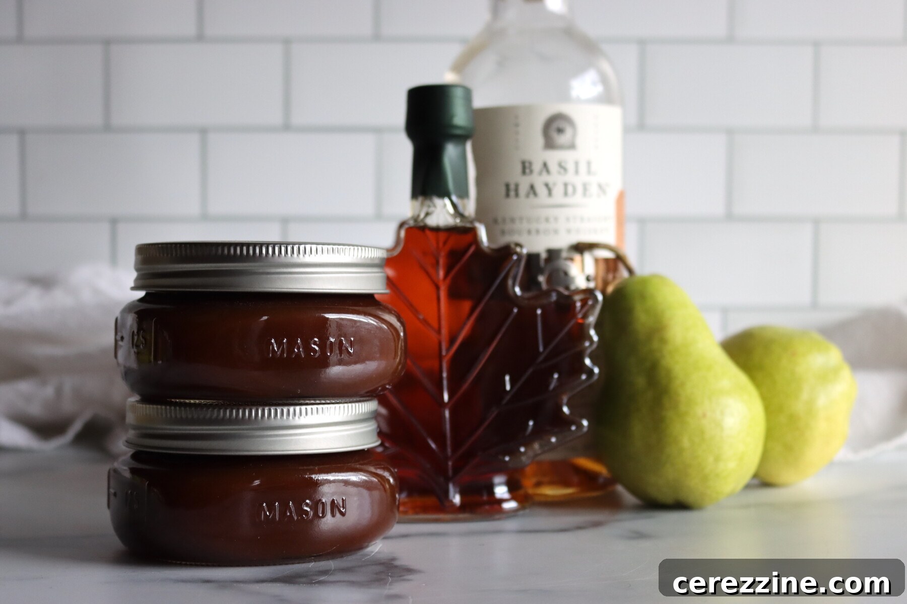 Maple Bourbon Pear Butter jars resting on a cooling rack after canning.