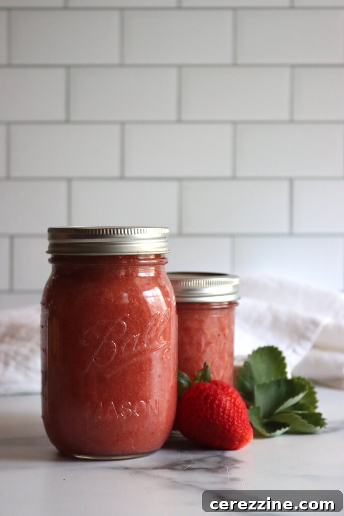 Blushing Berry Applesauce 3 Strawberry Applesauce in two canning jars on a white surface.