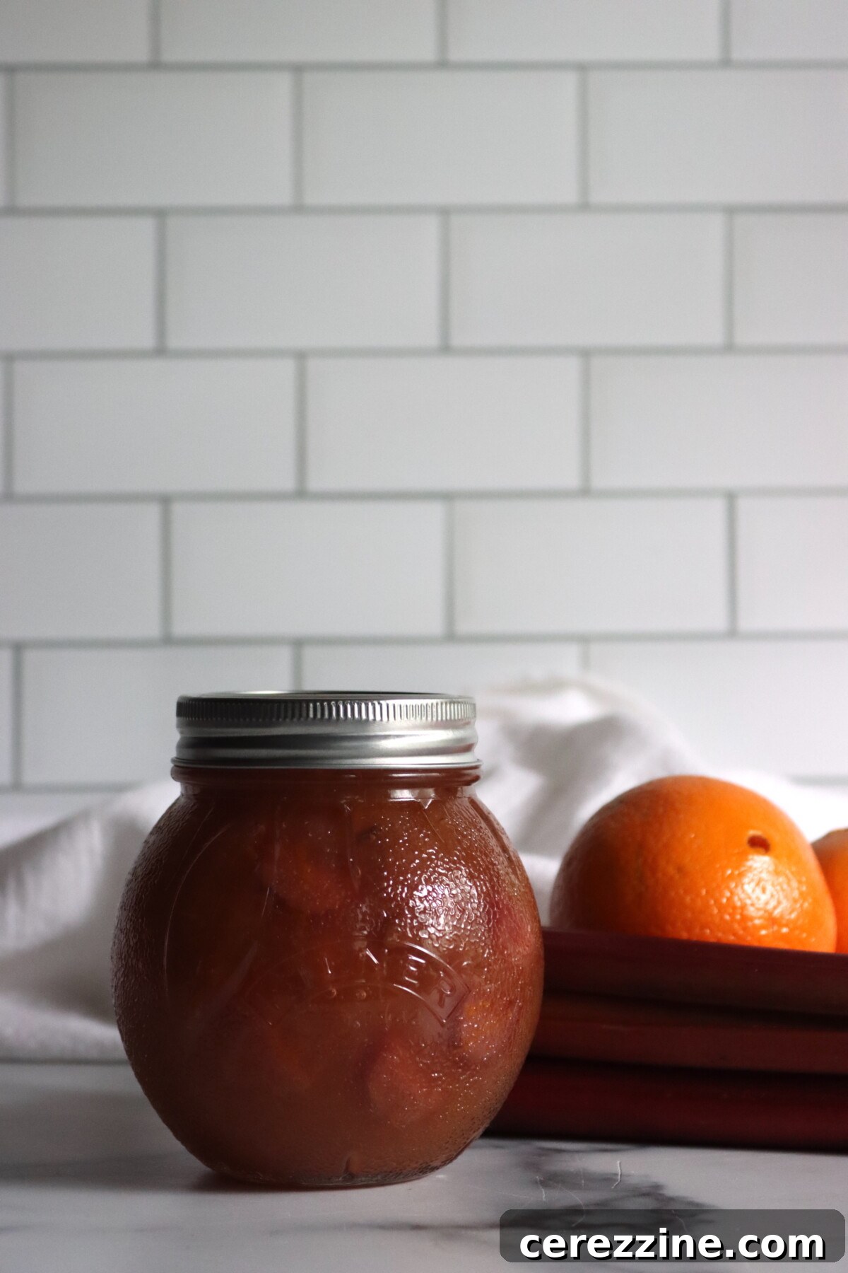 Close-up shot of the texture of finished Rhubarb Orange Jam in a jar.