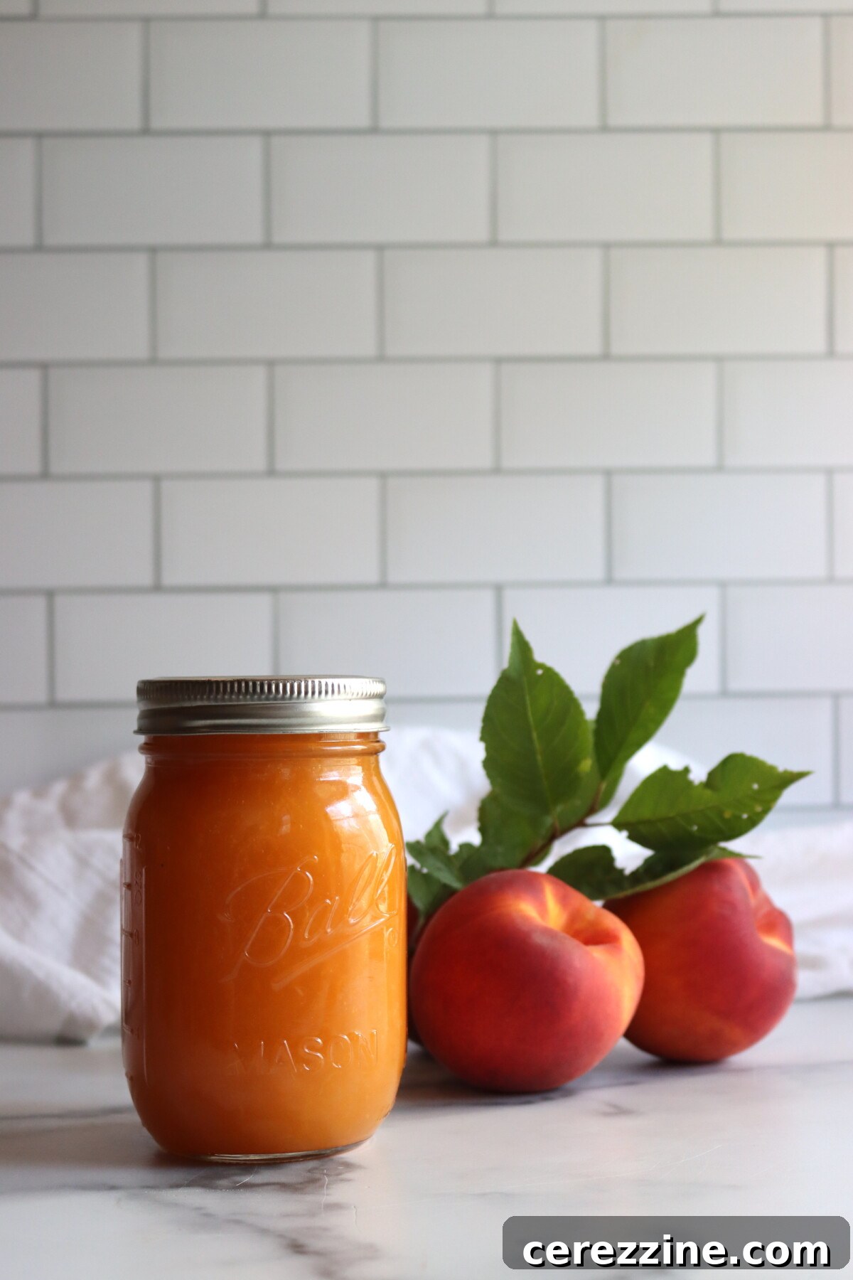 Finished peach applesauce in a jar with a spoon