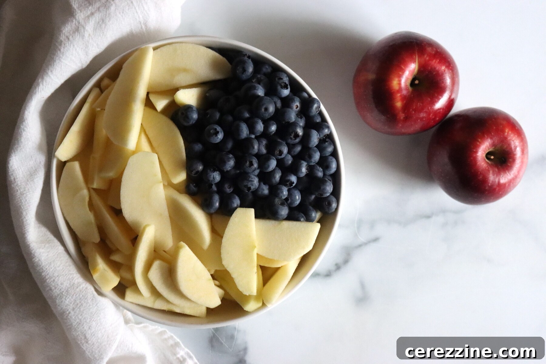 Apples and blueberries prepared for making blueberry applesauce