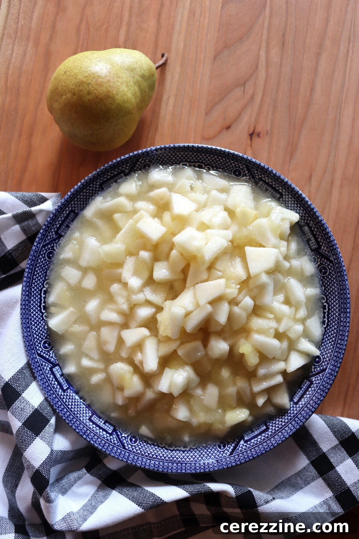 Bowl of diced pears for pear honey next to a whole pear