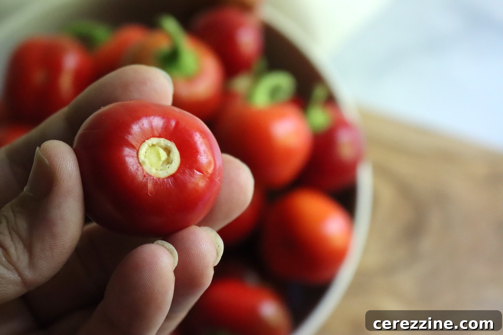 A cherry pepper with the top popped off, still whole