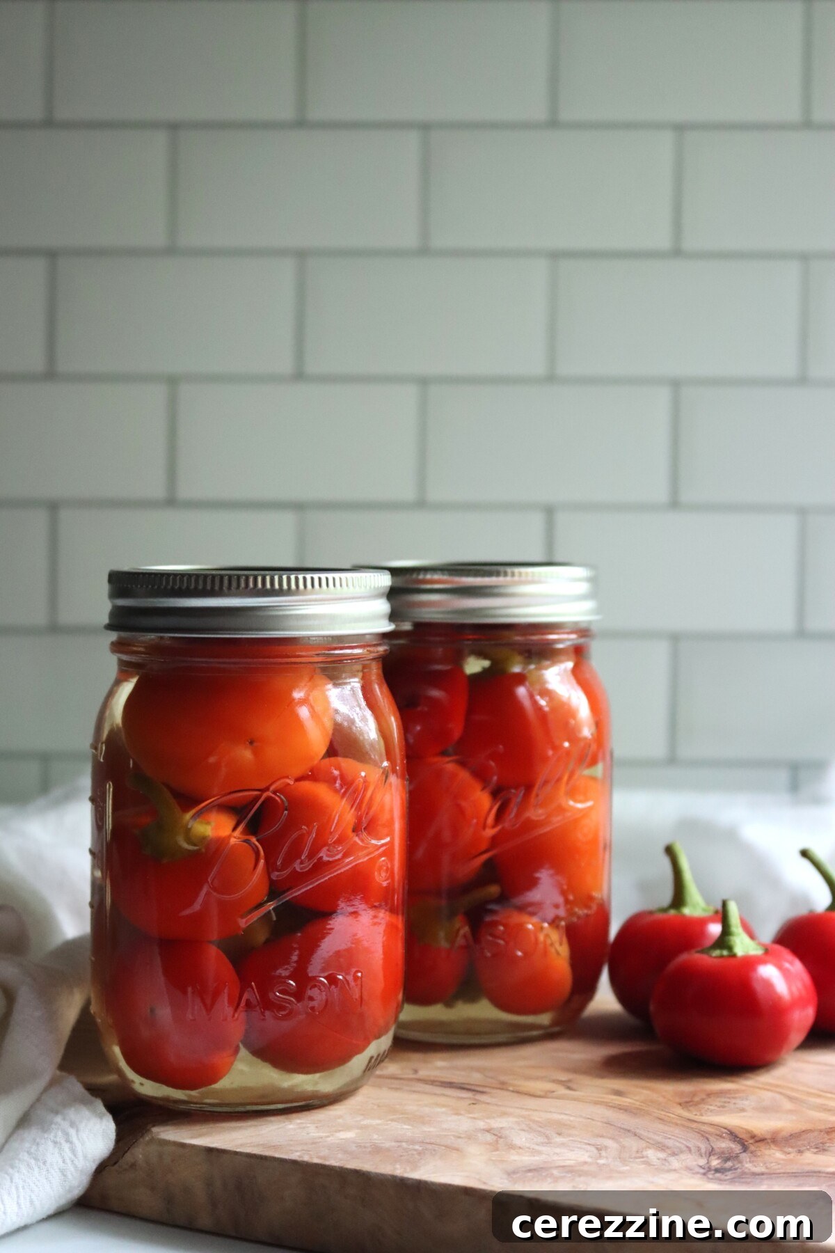 Two pint jars of home canned pickled cherry peppers, packed whole