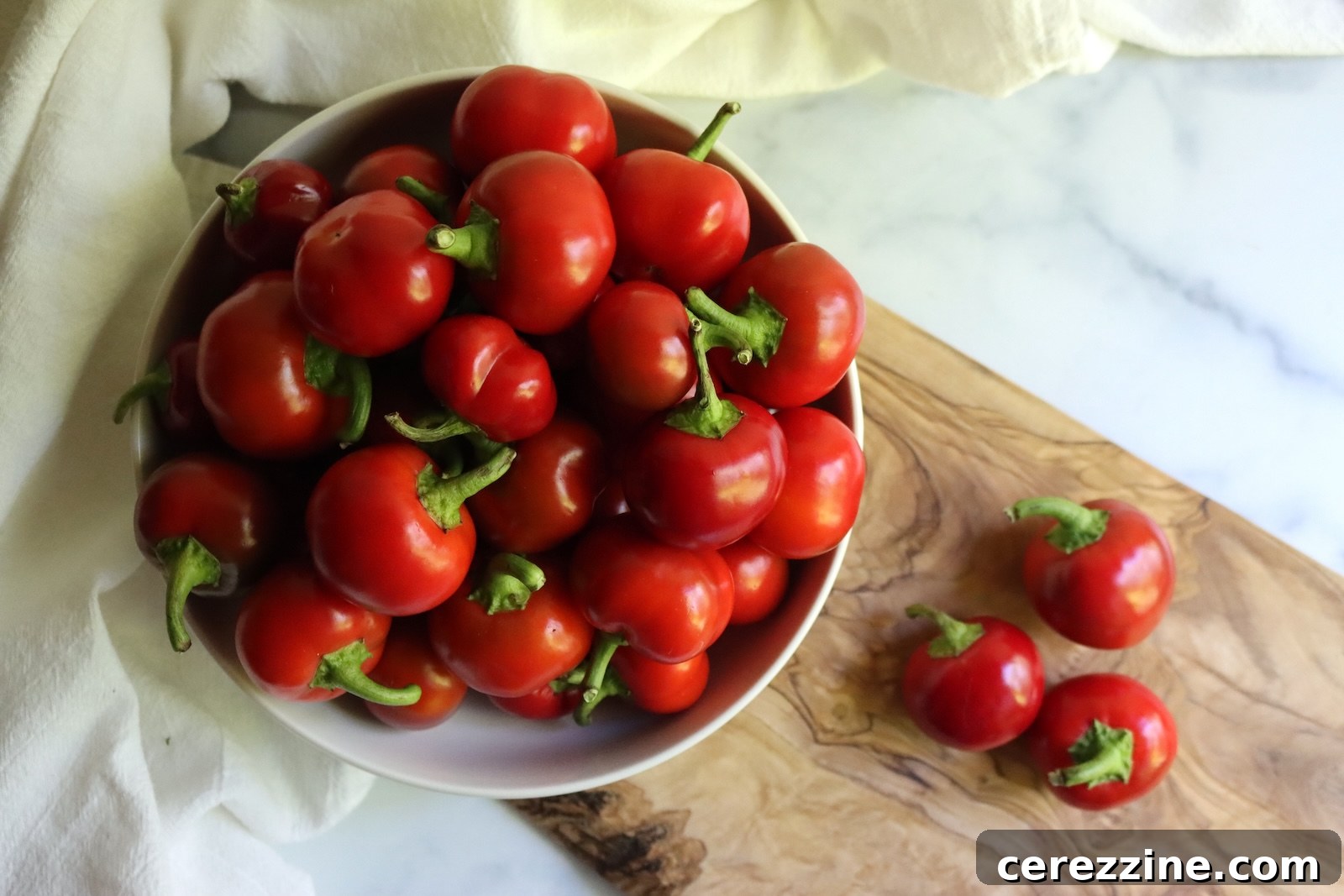 A bowl of fresh cherry peppers, sorted and ready to wash