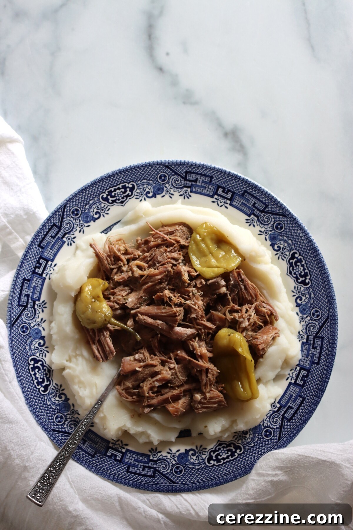Mississippi pork roast from a home-canned jar served over mashed potatoes with pepperoncini