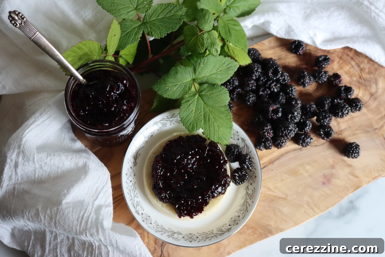 Homemade black raspberry jam on a plate with fresh blackcaps