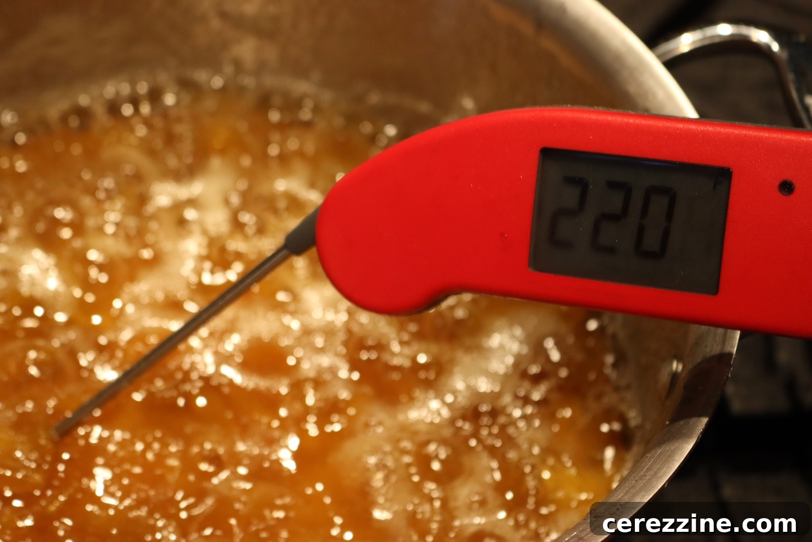 Thermometer reading 220 degrees F in boiling mirabelle plum jam
