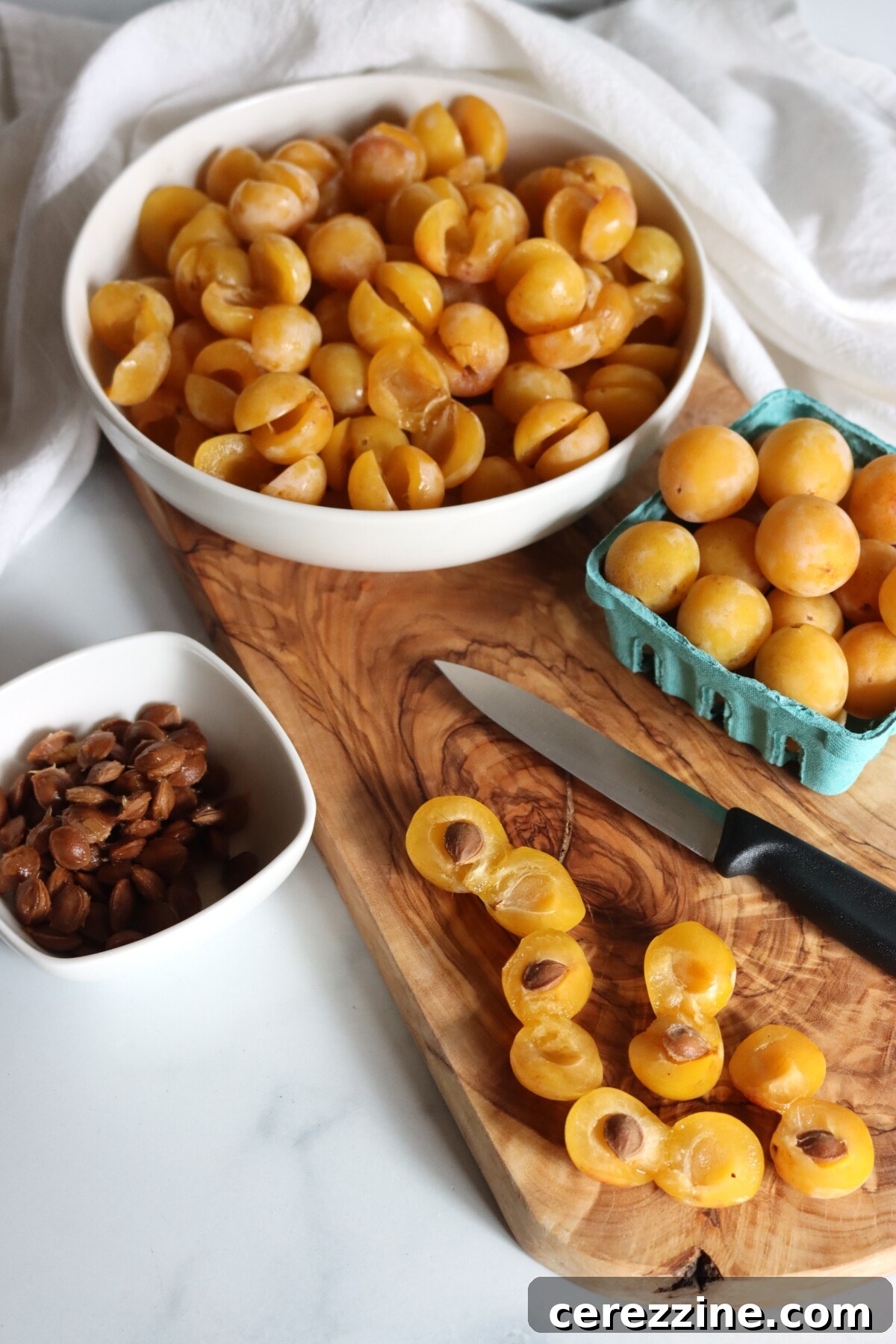 A bowl of halved mirabelle plums with the pits removed
