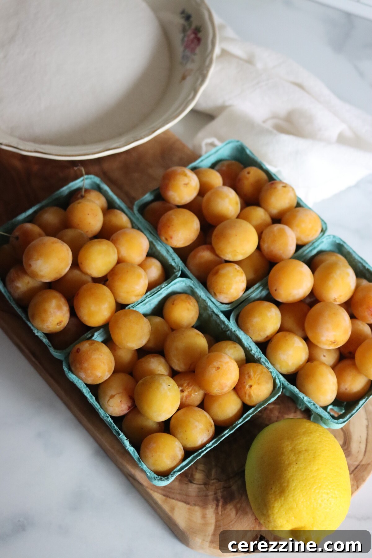 Mirabelle plum jam ingredients: fresh mirabelles, a lemon, and sugar