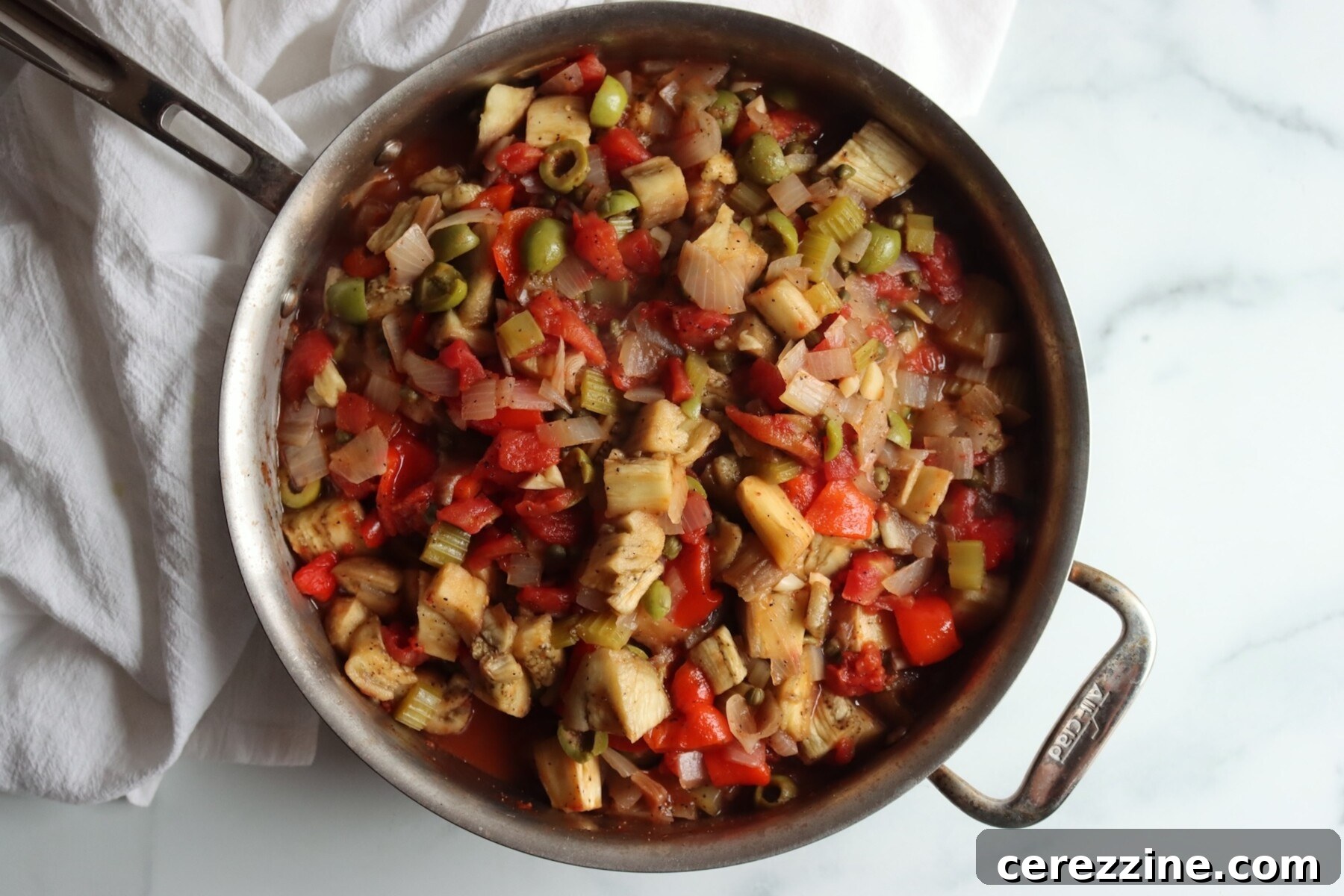 Eggplant caponata in the pan with the roasted eggplant and peppers stirred through