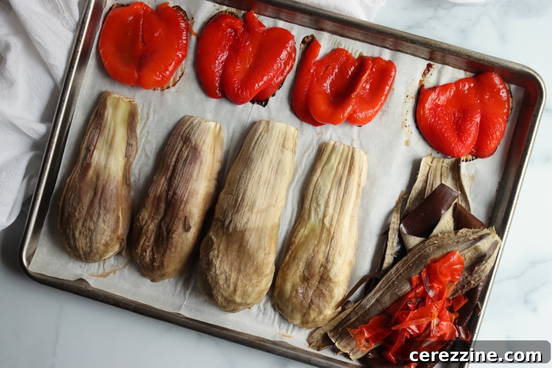 Roasted eggplant and red peppers with the skins pulled away, ready to chop
